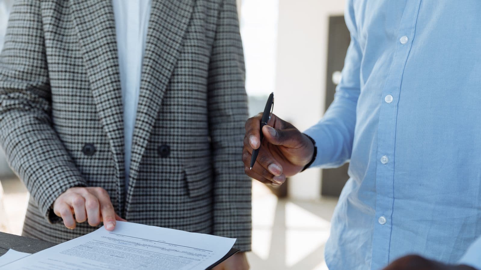 Deux associés signant les statuts d'une société en nom collectif dans un bureau